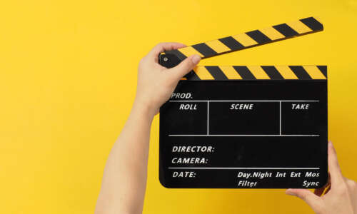 Top view. The hands are holding a black with yellow clapper boar